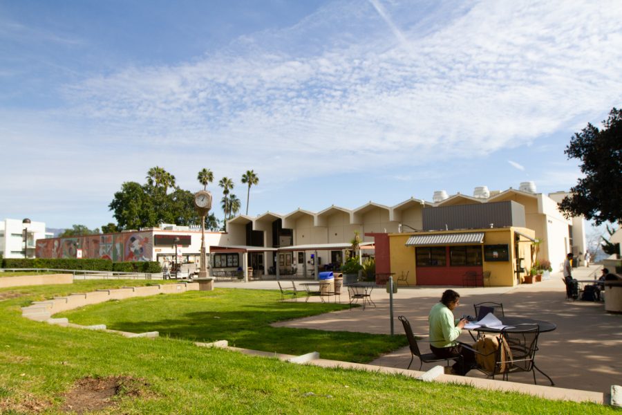 Glowing in the afternoon sun, the Campus Center houses the East Campus Cafeteria, CESJ, Umoja and Dream Center. Students sit outside on the tables socializing together and doing homework on Friday, Feb. 3.