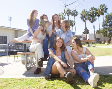 The Spring 2023 Editorial board sit on the tables outside of the newsroom, wearing coordinated outfits to match The Channels rebrand on Thursday, Feb. 9.