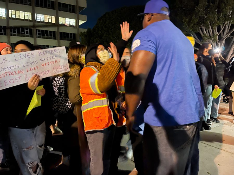 Protesters gather on March 1 in front of Campbell Hall at the University of California Santa Barbara in Isla Vista, Calif. The protester (center) puts her hand up in front of a supporter of Charlie Kirk.