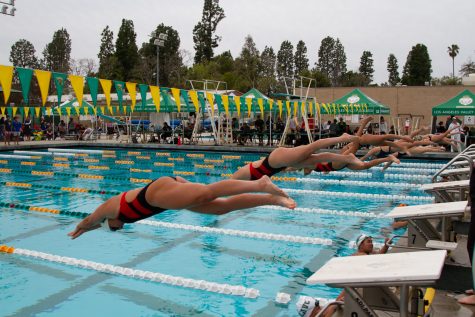 A line of swimmers dive off the starting blocks as a race begins on March 18, 2023 at Los Angeles Valley Community College in Valley Glen, Calif. Swift entry into the water is essential for building speed in a race.