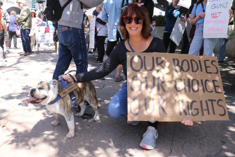 Lorena David and her canine companion Humphrey, gleam during the reproductive rights protest on April 15 in Santa Barbara, Calif. This if the third place hes gone with his signs, unfortunately, David said. Hes 9 years old, he shouldnt be standing for this anymore!