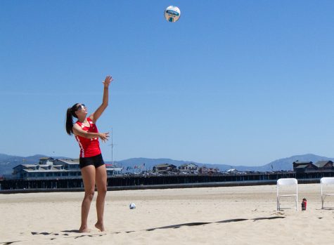 Jordan Anderson (No. 14) serves the ball to the opposite team during the Vaqueros beach volleyball tournament on Friday, April 21 at West Beach in Santa Barbara Calif.