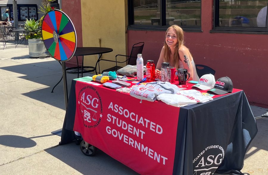Commissioner of Sustainability, Paige White, 20, tabling for Earth Week outside of the cafeteria on East Campus on Wednesday, April 19 in Santa Barbara, Calif. White let students spin the wheel to answer a question about the earth in order to win a prize.