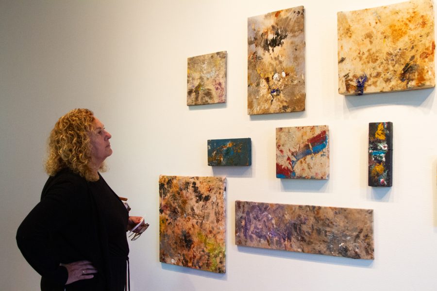 Geri Riehl admires the artwork from the sculpture gallery at the Atkinson Gallery. The exhibition is a cultivation of student work from the sculpting department at City College. Members of the community came to view the exhibition during the opening reception Thursday, April 6 at the Atkinson Gallery on East Campus.