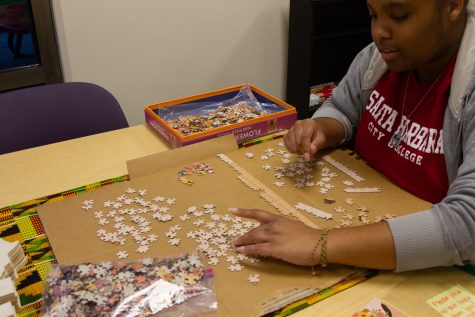Zoe Fleming works on a puzzle on the arts table during the Black History 365 event that was held by Umoja on Wednesday, Feb. 15 at City College.