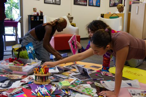 Jaili Reed reaches over to grab a pair of scissors to begin cutting out a new piece for her vision board on Tuesday, Feb. 28 at City College.