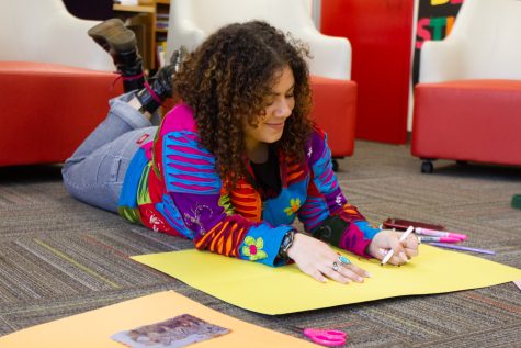 Stella Stretch lays in colorful clothing with a blank piece of yellow paper getting ready to start her vision board on Tuesday, Feb. 28 at City College.