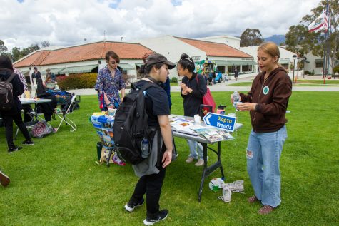 Paige White, ASG’s commissioner of sustainability, demonstrates the use of traditional dishware from Nepal at the country’s booth on Thursday, May 4 in Santa Barbara, Calif. “Be careful or it will overflow,” White said.