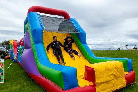 From left, friends Brite Kaufhoid and Kaden Keely slide down the “Unity in The Community” jolly jump on Thursday, May 4 in Santa Barbara, Calif. The festival offered a variety of other activities, including soccer and lawn games.