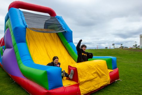 From left, friends Brite Kaufhoid and Kaden Keely slide down the “Unity in The Community” jolly jump on Thursday, May 4 in Santa Barbara, Calif. The festival offered a variety of other activities, including soccer and lawn games.