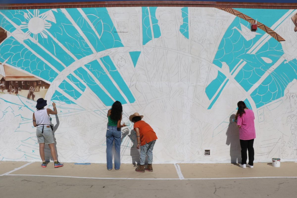 City College students follow the guidance of the Twin Walls Mural Company to contribute to the mural outside of the cafeteria on east campus on Sept. 12 in Santa Barbara, Calif. The muralists marked spaces on the wall that needed to be colored in by the volunteers.