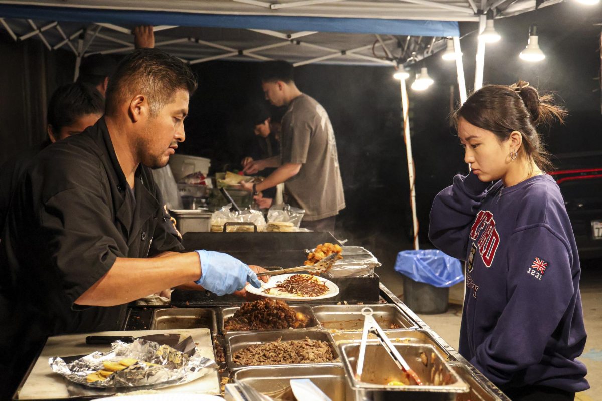 Roger Jimenez constructs a carne asada quesadilla on Saturday, Sept. 30 in Isla Vista, Calif. Roger offers three kinds of meat for his dishes: carne asada, adobada, and chicken.