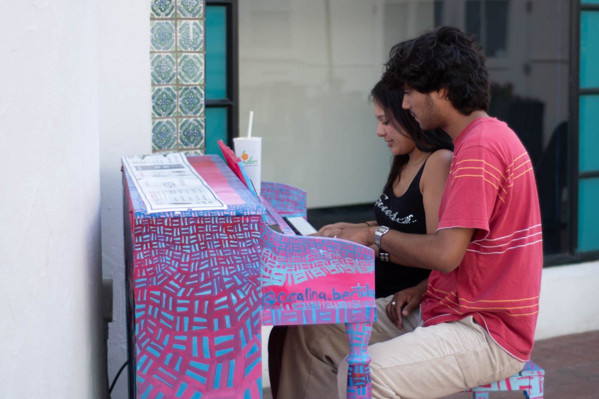 City College student Isabelle Martinez (left) teaches Anthony Almazon songs on a piano that was painted by artist Catalina Bertola on Oct. 12 on State Street in Santa Barbara, Calif. "We come here every Tuesday and Thursday to learn new songs," Martinez said.