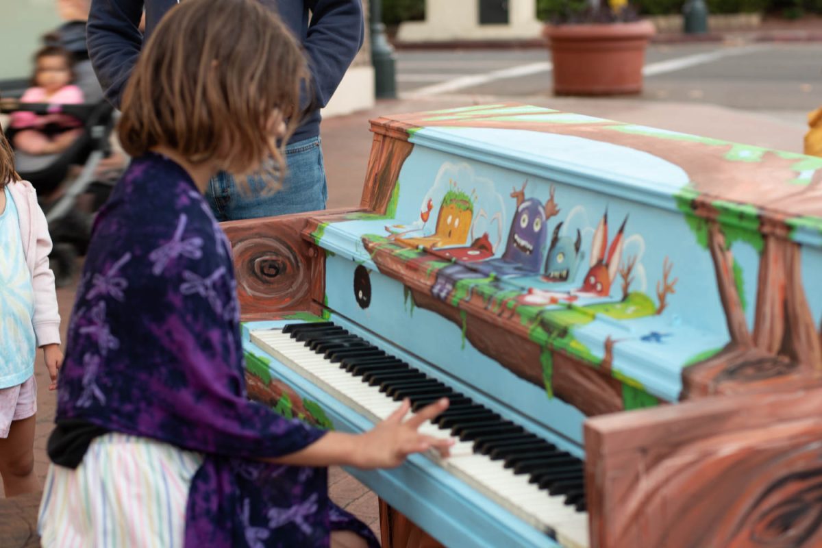 Lorelei Donaire plays a few more notes before giving her sister Temperance a turn at the keys on Oct. 10 on the corner of Anapamu and State streets in Santa Barbara, Calif. Artist Jen Swain painted this monster-themed piano.
