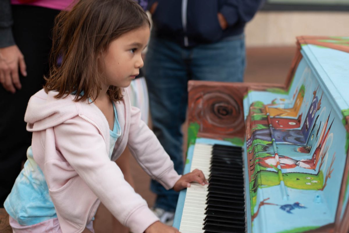 Temperance Donaire plays a monster-painted piano for her family on Oct. 10 in Santa Barbara, Calif. This piano was painted by Jen Swain and sits on the corner of Anapamu and State streets.