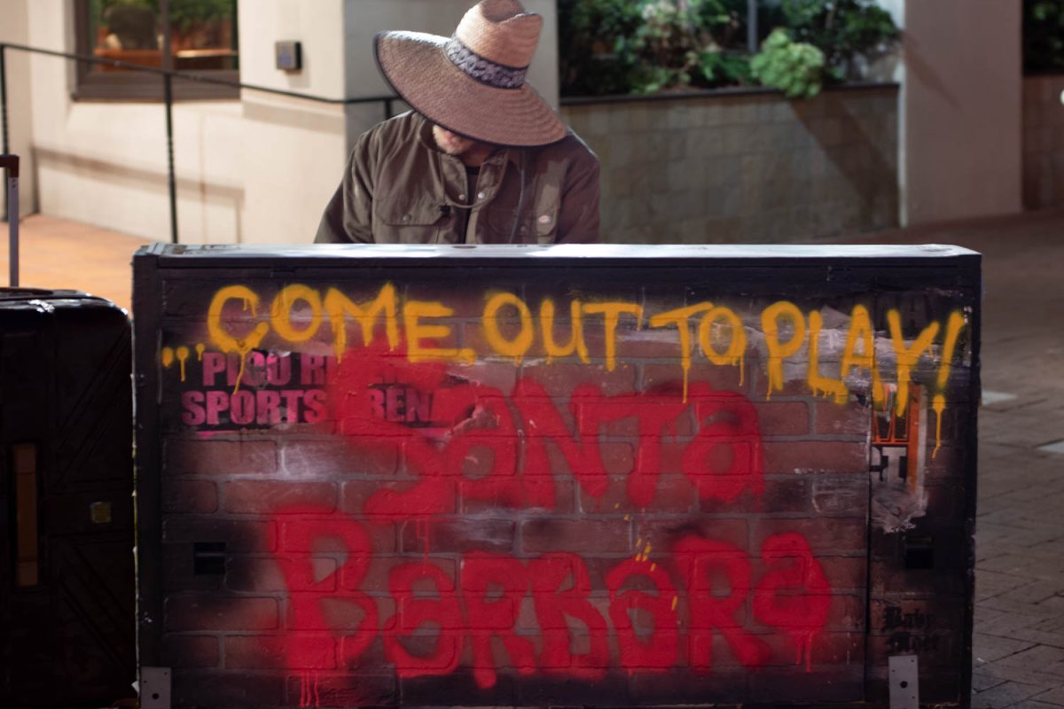 Brett Lee plays a few notes on the piano before moving on with his night on Oct. 10 on the corner of Victoria and State Streets in Santa Barbara, Calif. This piano was painted by Artist Baby Moet.