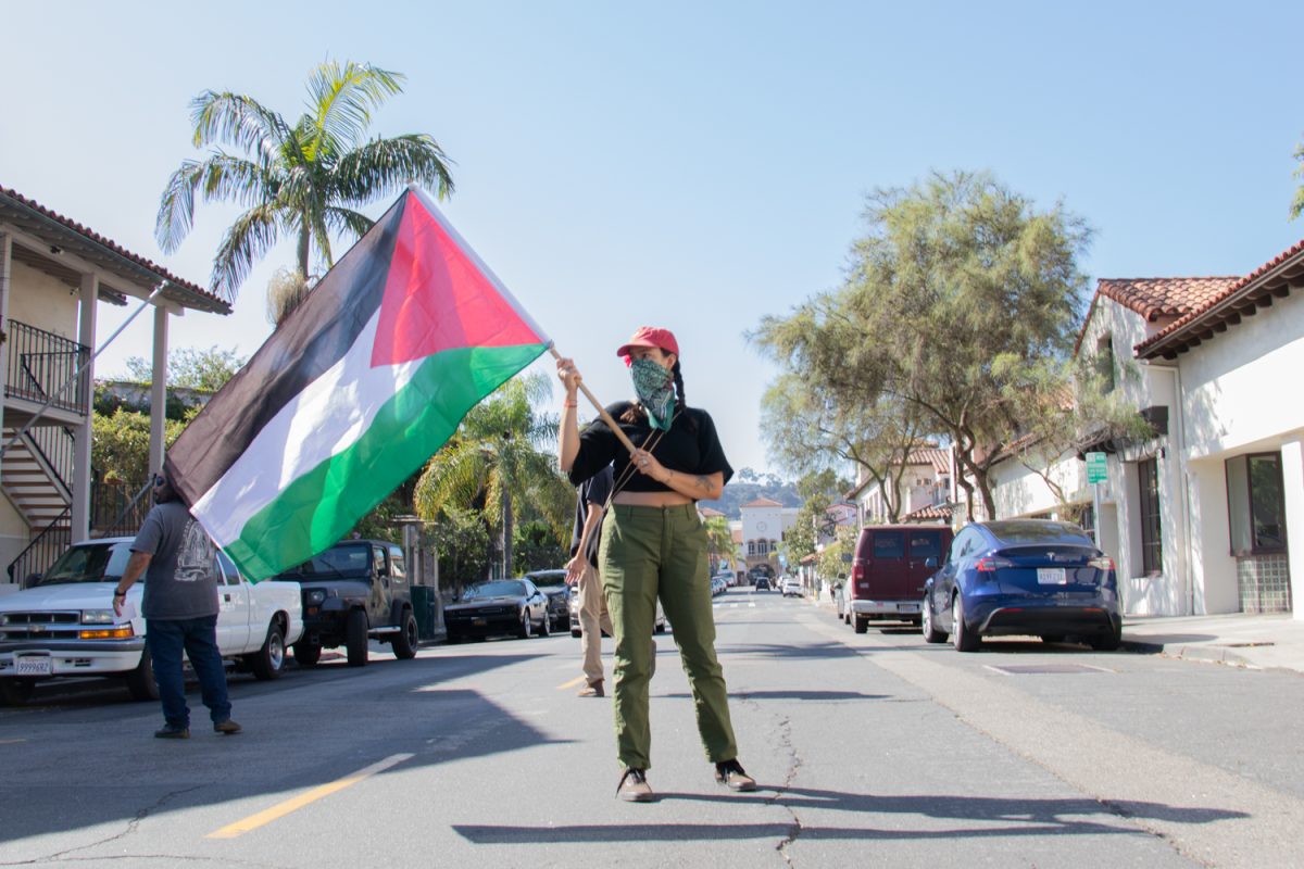 A woman waves a Palestinian flag during the protest directed by Jewish Voice for Peace on Oct. 24 in Santa Barbara, Calif. While some of the members march up to Congressman Carbajal's office, the remaining members chant on the street.