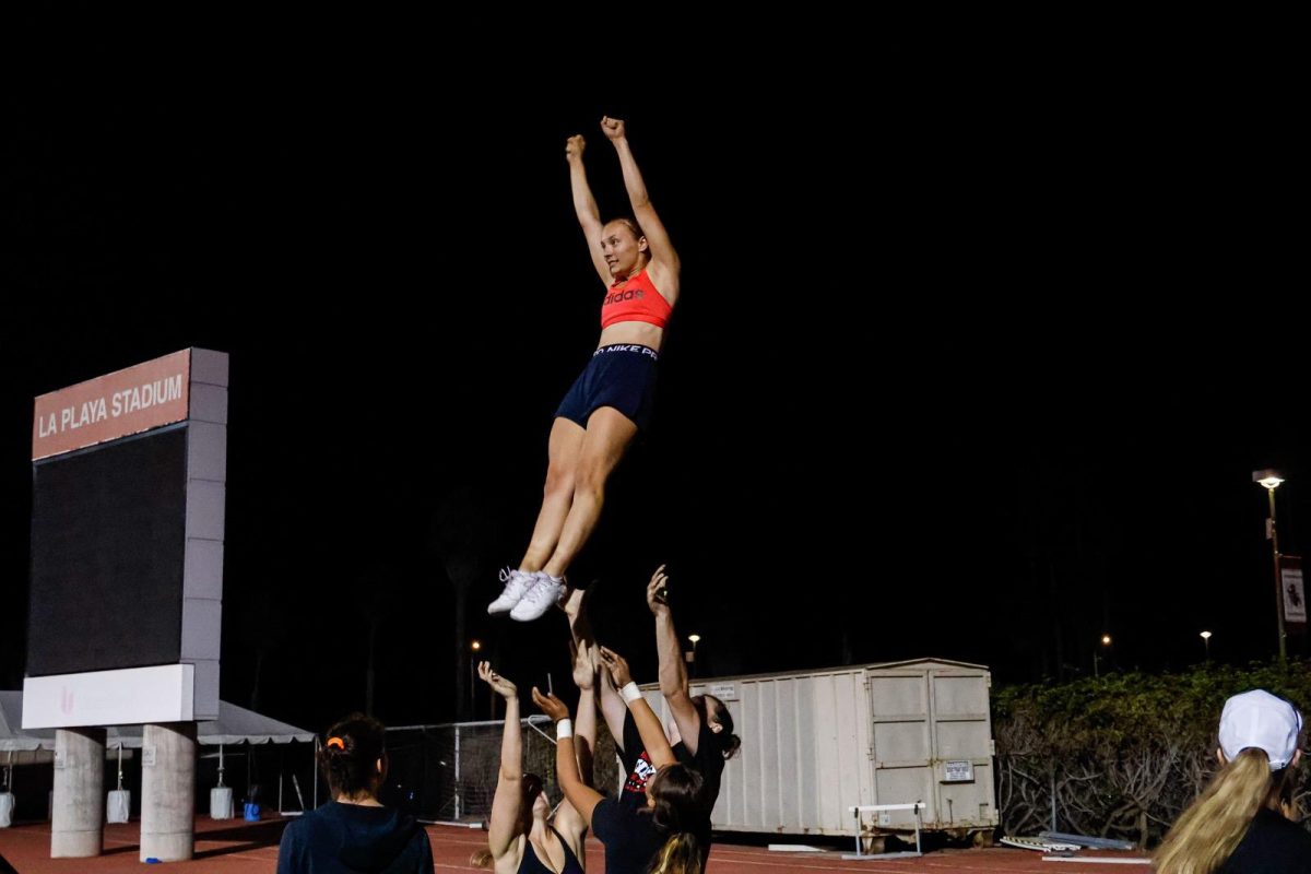 Acelyn Sutton soars through the air on Sept. 28 at City Colleges La Playa Stadium in Santa Barbara, Calif. Four of her teammates prepare to catch her.