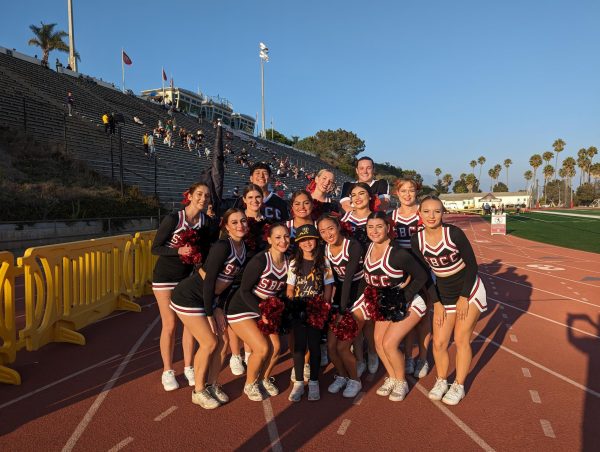 The SBCC cheer team gathers around a young guest captain at City College's La Playa stadium in Santa Barbara, Calif. The team participates regularly in community-building efforts. (Courtesy of Julia Hand)