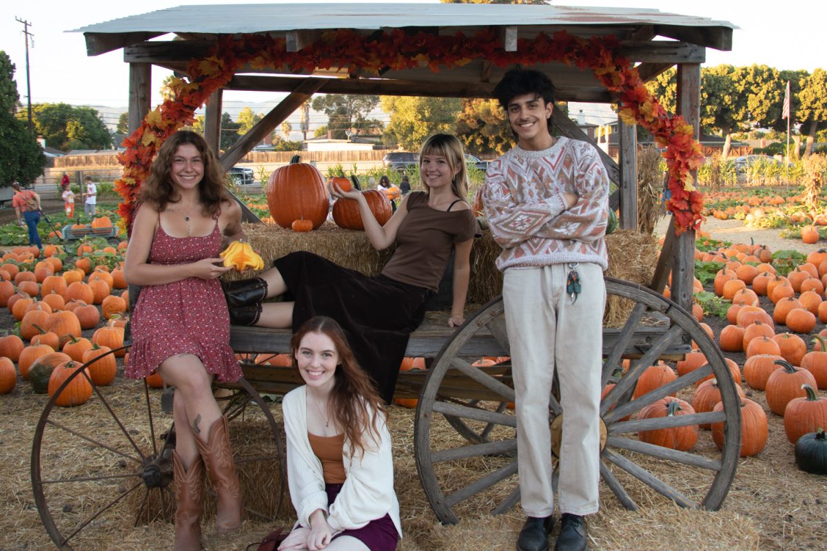 From left, Sofia Stavins, Claire Geriak (on wagon), Delaney Newhouse below, and Angel Corzo gather in front of a wagon on Oct. 20 at Lane Farms in Santa Barbara, Calif. These four make up The Channels editorial board for the fall 2023 semester. 