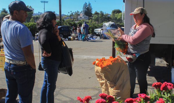 Rosa Jimenez sells flowers for the holiday the Day of the Dead on Saturday, Oct 28 at the Santa Barbara High school in Santa Barbara, Calif. Jimenez normally sells perfume, but changed her product for the special occasion.