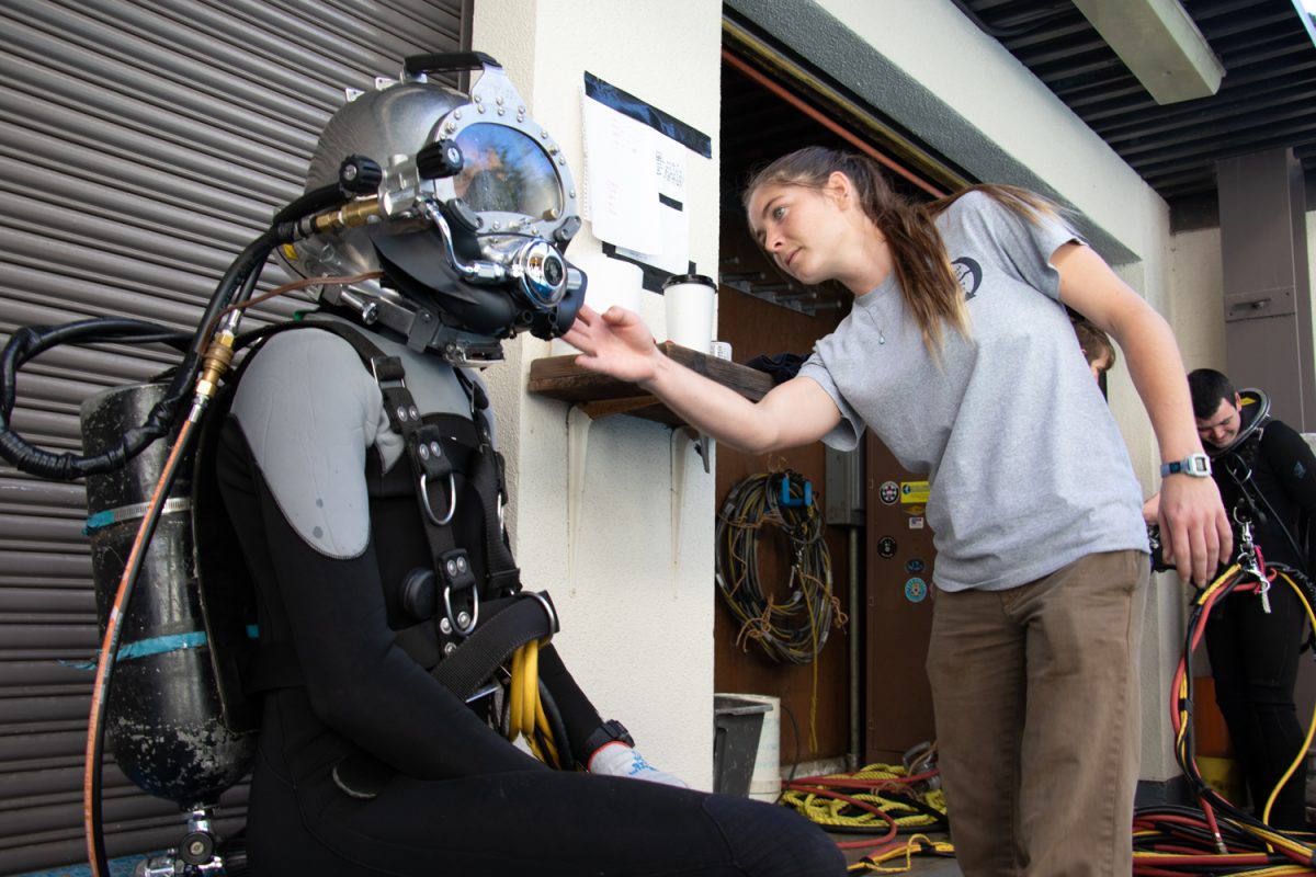 Alina Synder adjusts Gabe Langers scuba mask in preparation for his dive on Oct. 7 at City College in Santa Barbara, Calif. On the scene, Synder assisted Langer with all of his chords and gear before his dive.