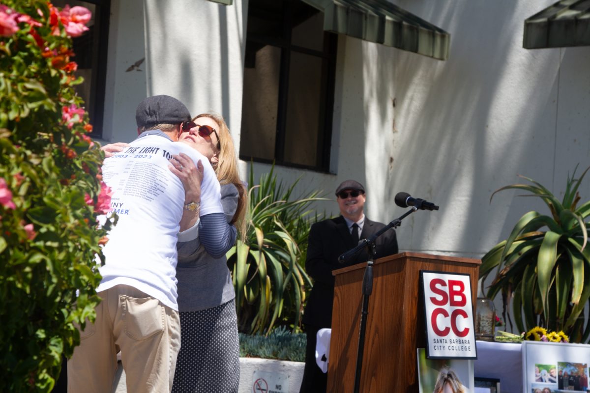 From left, Benjamin Schurmers Father Glenn, as he embraces Superintendent-President Erika Endrijonas in front of campus Chaplin Jason Walker on Friday, April 26 at the steps of the Luria Library on City Colleges West Campus in Santa Barbara, Calif. The Flag Lowering Ceremony, hosted by City College, granted Schurmer an associate of arts degree on behalf of the college. 