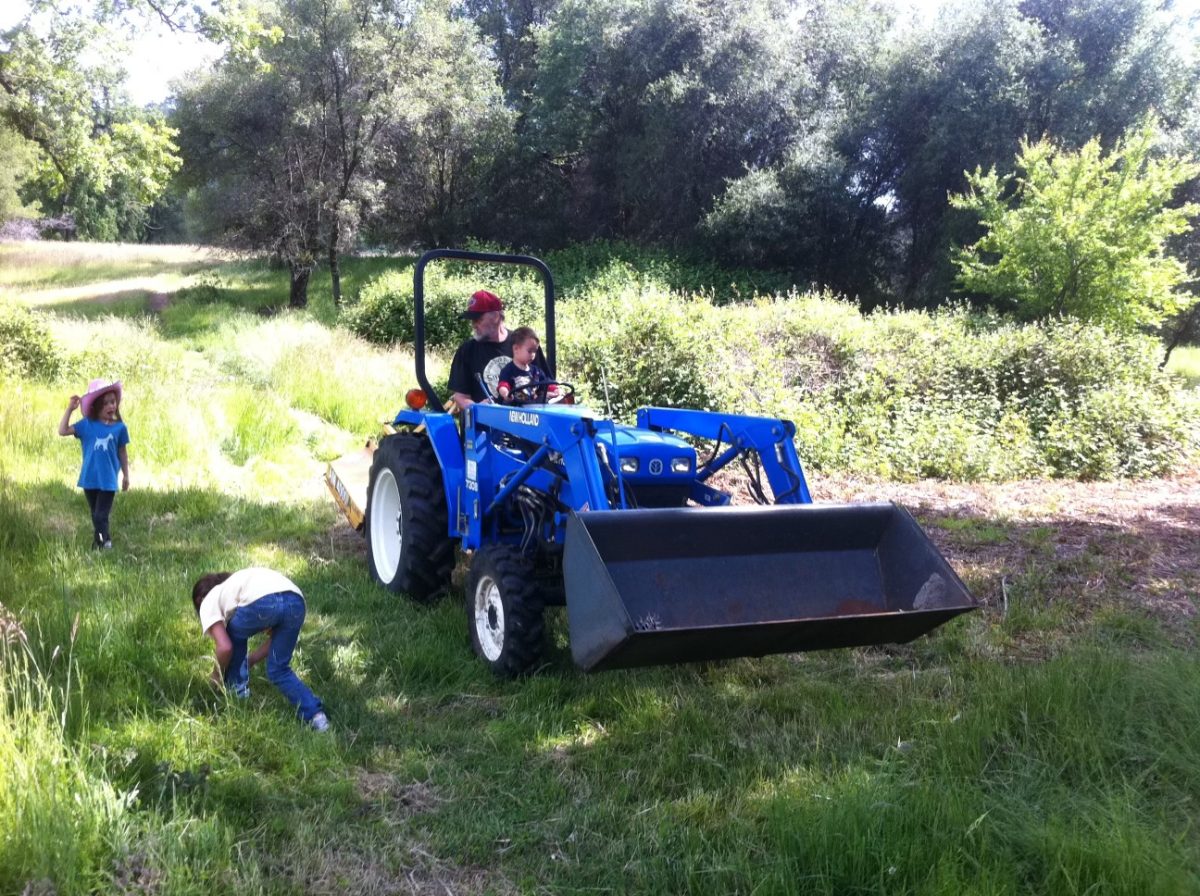 From left, Anneli Larson struts in style with her pink cowgirl hat and her sister, brother and grandpa on his farm back in 2011 in Grass Valley, Calif. They are helping with the daily chores and taking turns driving the tractor.