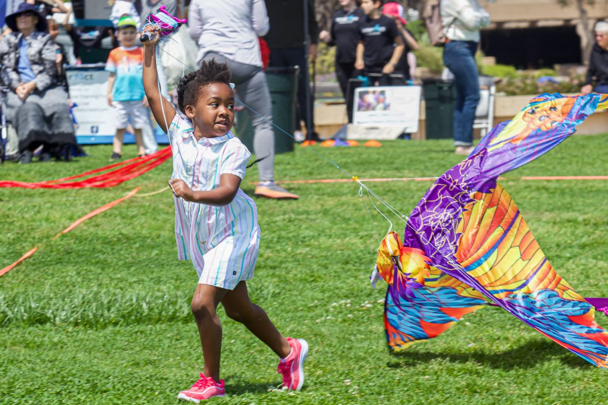 Joy, 5, runs with her kite at the Kite Festival on April, 21, 2024 at the Great Meadow at City College in Santa Barbara, Calif. "Learning how to fly a kite... we've been trying to learn for years and now we have plenty of people here to helps us", Joy's mother said.