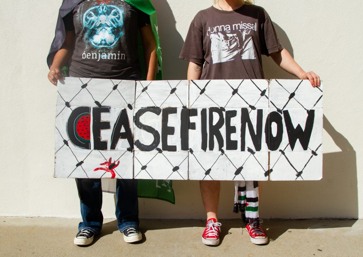 Two members of City Colleges Students for Justice in Palestine (SJP) club hold a handmade picket sign calling for a ceasefire between Israel and Palestine on Monday, April 29. The club members requested The Channels keep their identity hidden.