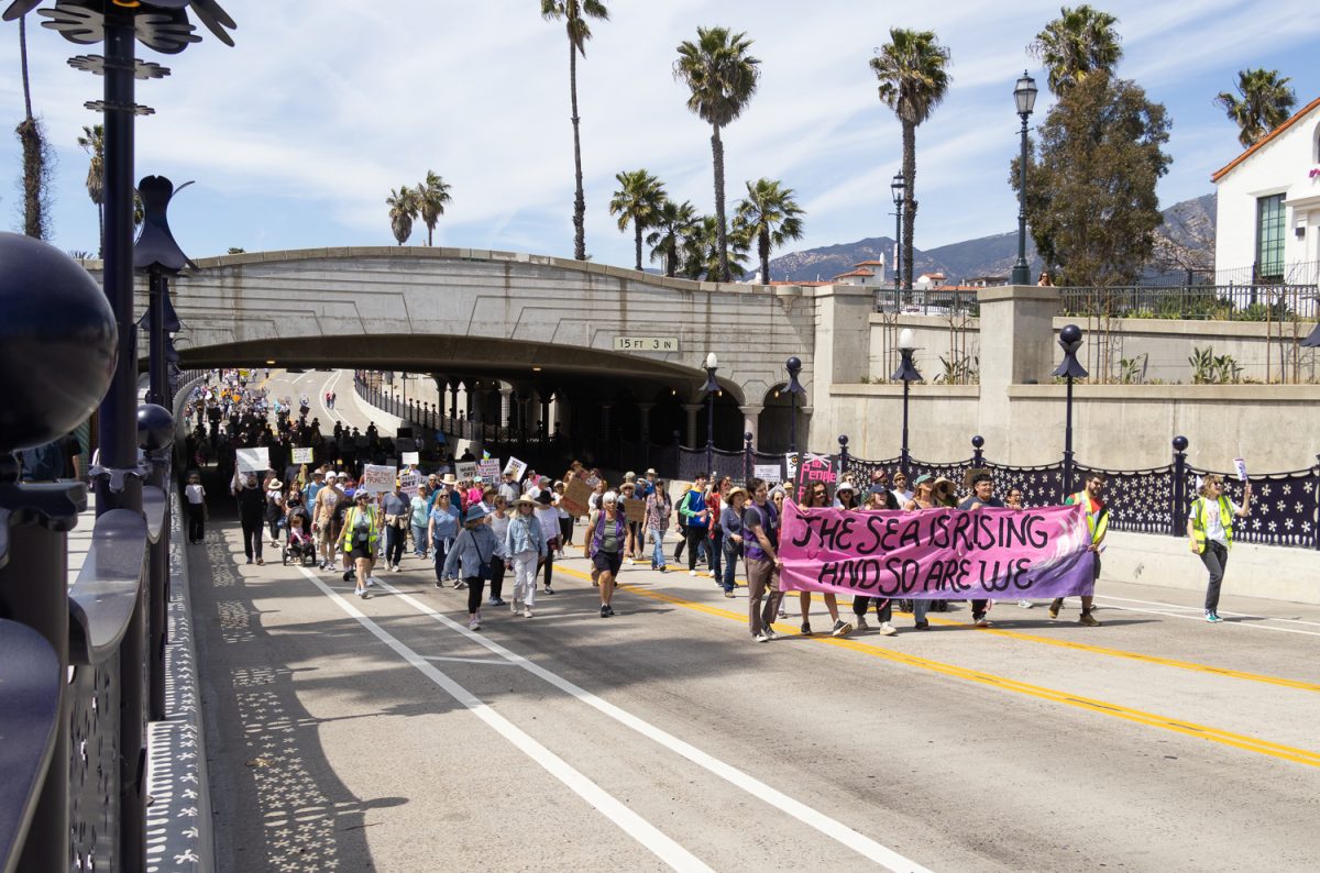 Hands Off protestors march below State Street’s underpass April 5 in Santa Barbara, Calif. “Hands off our schools” they chanted.